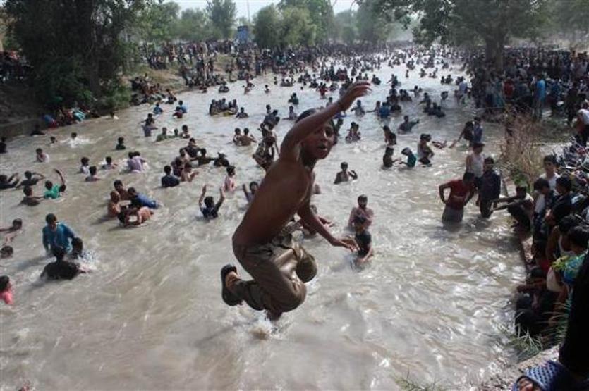 Pakistanlılar su kanalında serinliyor