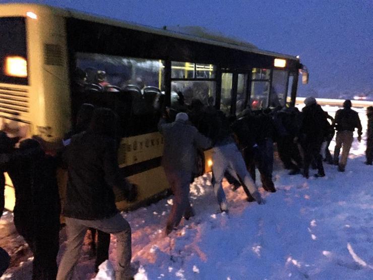 Dağ yolunda karda kayan otobüsü yolcular itti