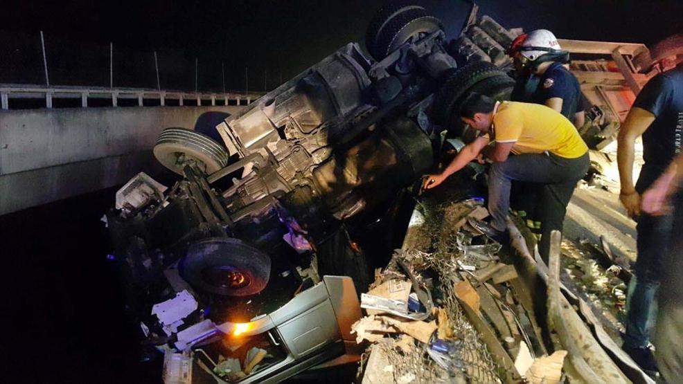 Kaza yapan TIR saatlerce köprüde asılı kaldı