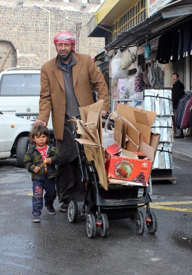 Oğlunun bebek arabasıyla atık topluyor