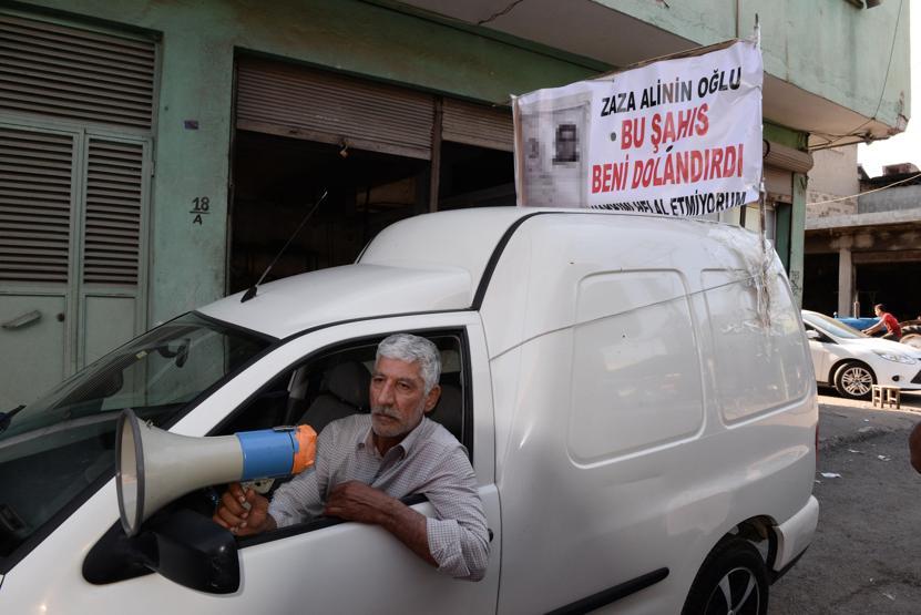 Alacaklısının kimliğini pankart yapıp aracına astı