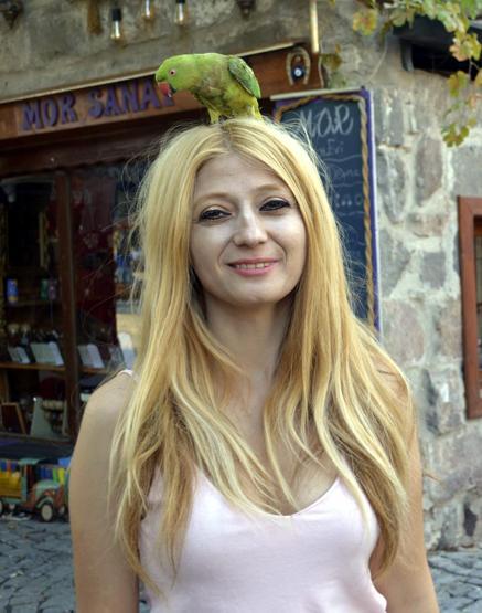 Kuşlarını gezdirip, soru soran ve fotoğraf çektirenden para alıyor