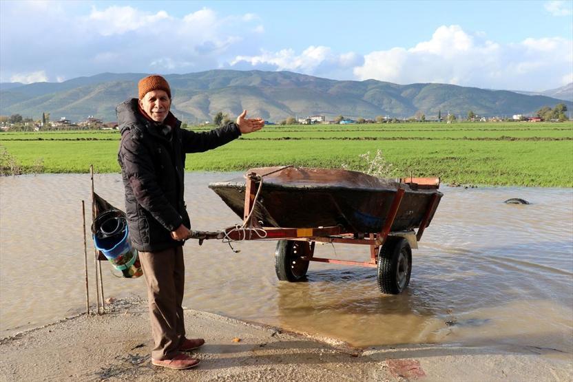 Yağmur sularının altında kalan tarlasını kayıkla gezdi