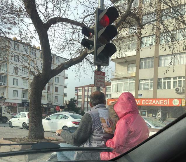 Sürücülerin dikkatini çekti... Motosiklet üzerinde ders kitabını okudu