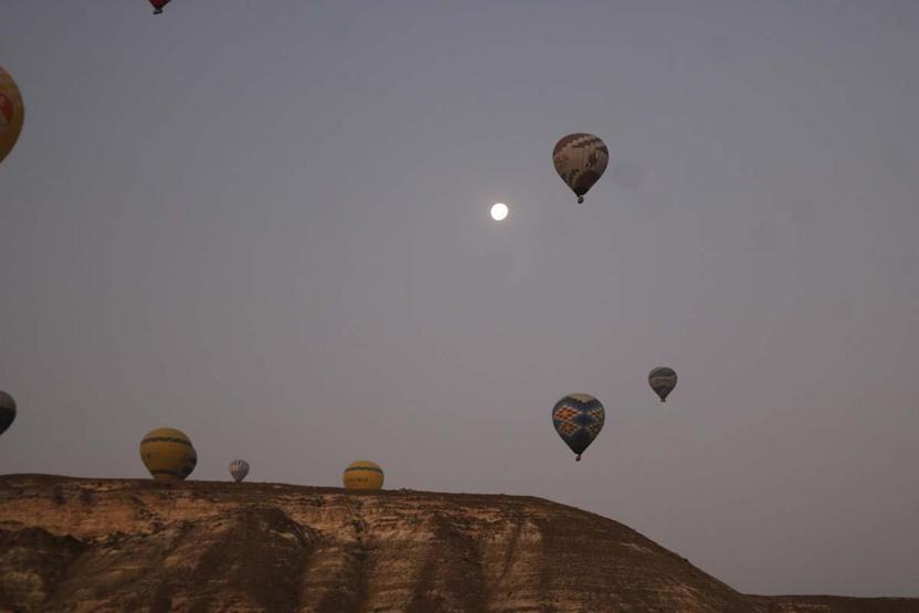 Kapadokya’ya tatil için gelen turistler, bölgeyi sıcak hava balonuyla izliyor