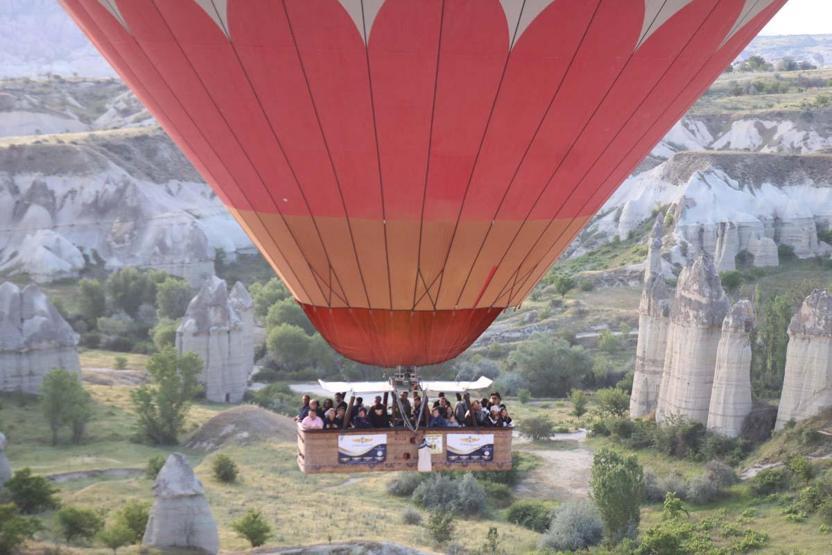 Kapadokya’ya tatil için gelen turistler, bölgeyi sıcak hava balonuyla izliyor