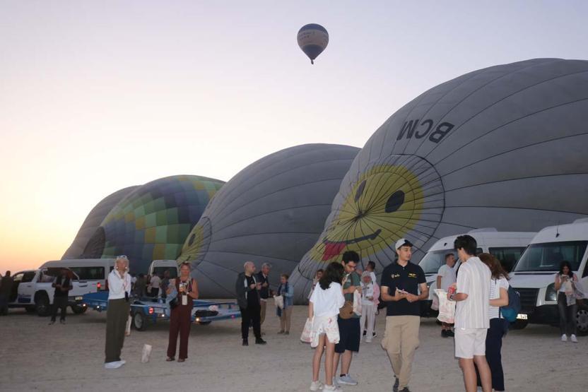 Kapadokya’ya tatil için gelen turistler, bölgeyi sıcak hava balonuyla izliyor