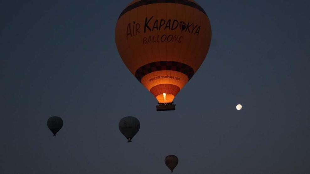 Kapadokya’ya tatil için gelen turistler, bölgeyi sıcak hava balonuyla izliyor