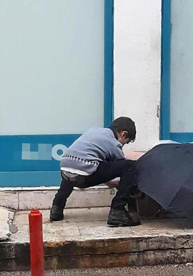 Şemsiyesiyle sokak köpeğini yağmurdan korudu