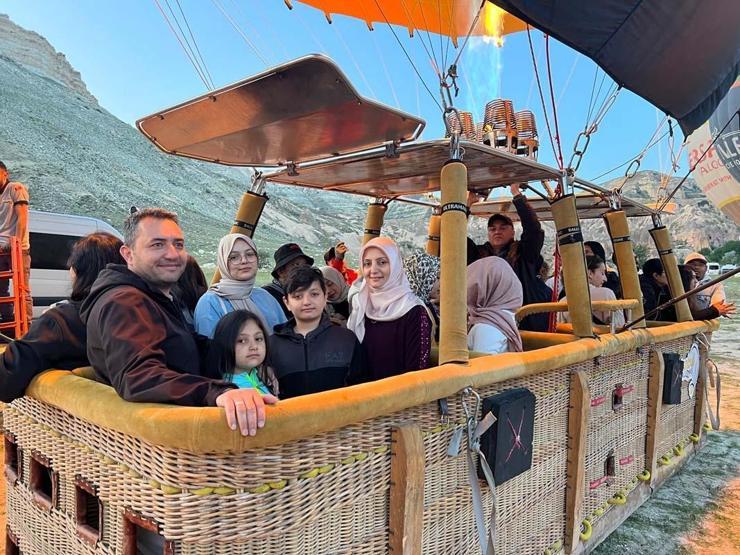 Kapadokya’ya tatil için gelen turistler, bölgeyi sıcak hava balonuyla izliyor