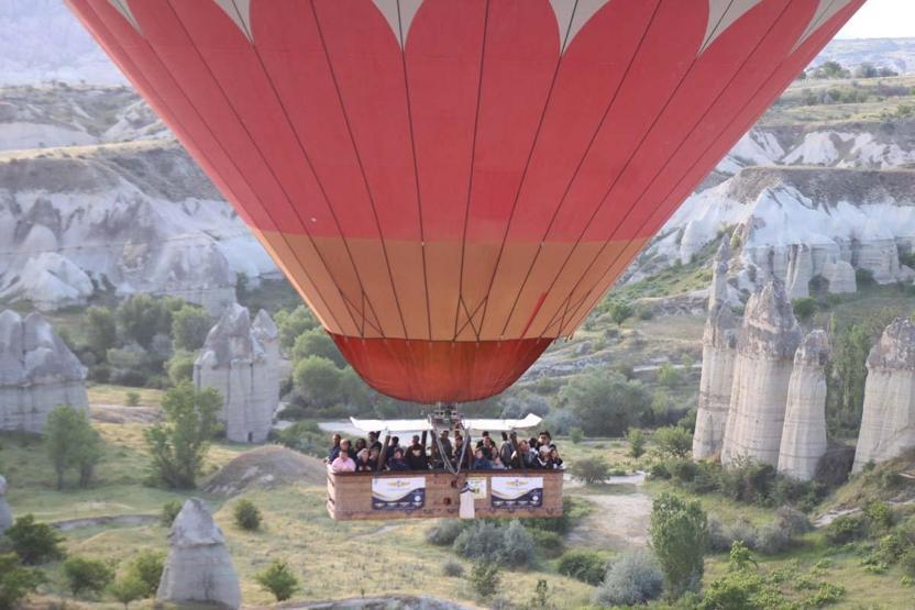 Kapadokya’ya tatil için gelen turistler, bölgeyi sıcak hava balonuyla izliyor