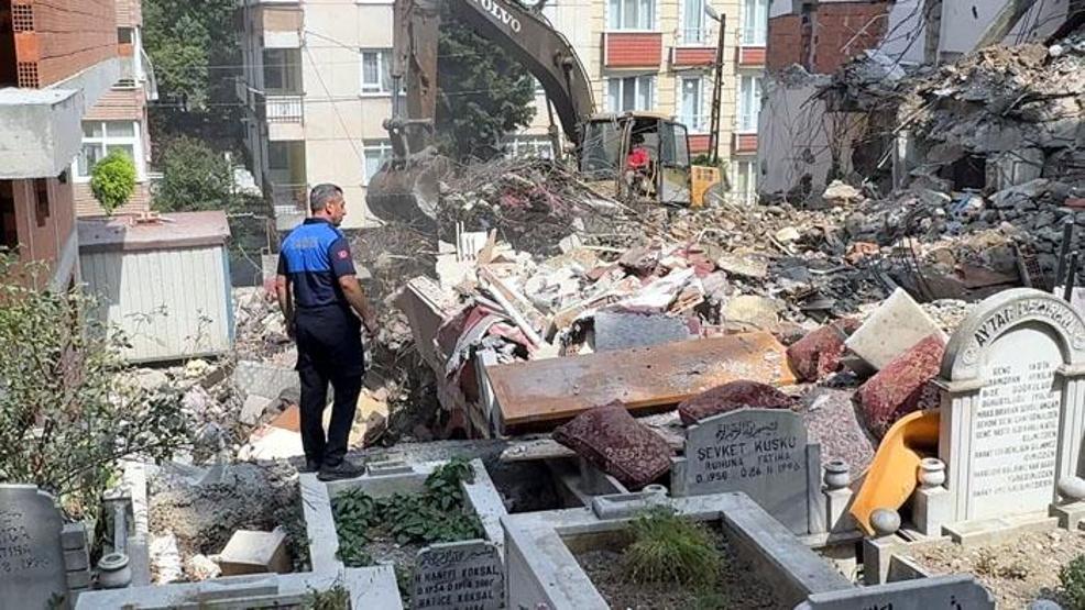 Yıkılan binadan mezarlığa moloz düşmesin diye yastıklı önlem
