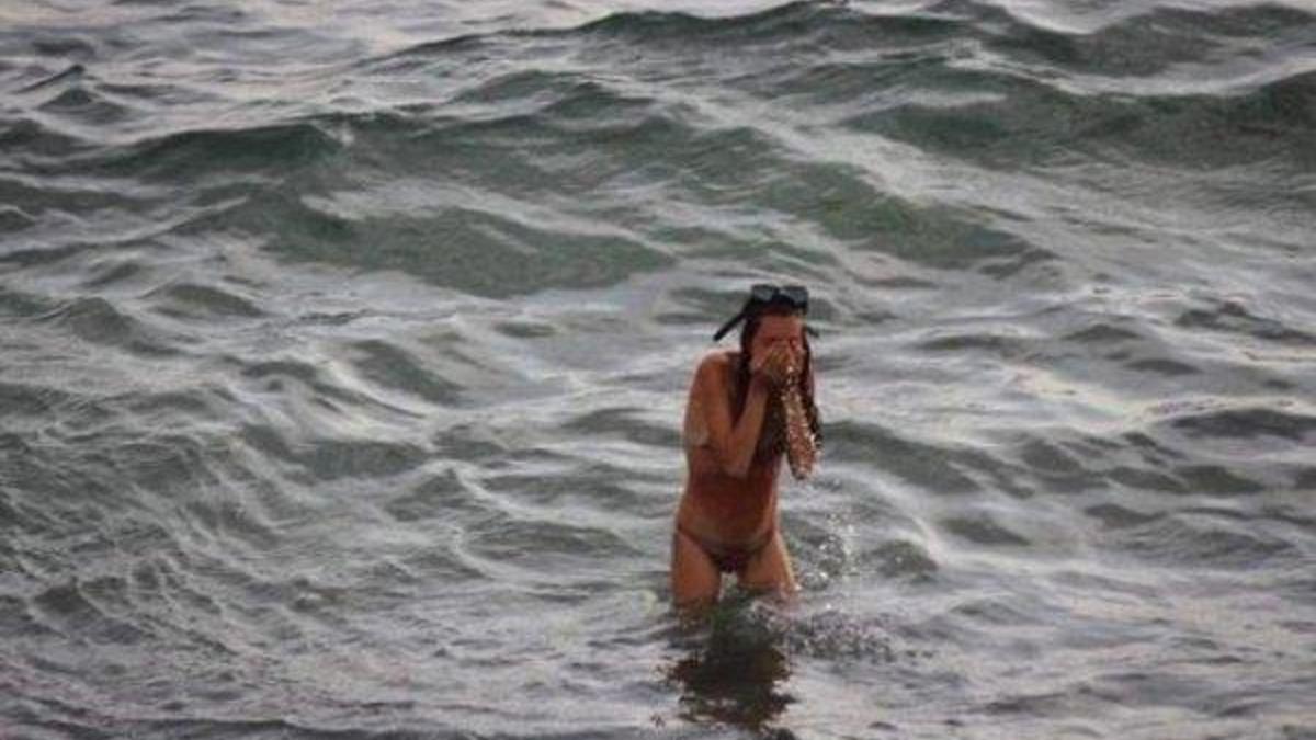 Голая девушка купается в море в жару