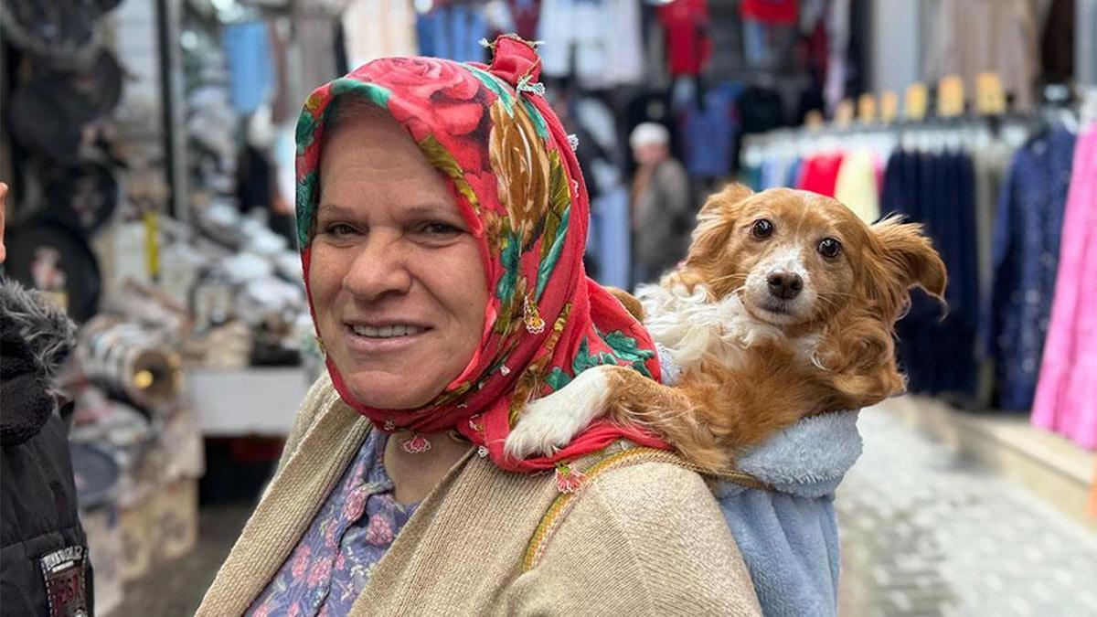 İnsanlardan korkan köpeğini sırtında gezdiriyor