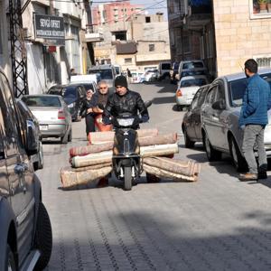 Evinin halılarını elektrikli bisikletle taşıdı