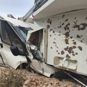 Kum yüklü kamyon minibüsün üzerine devrildi