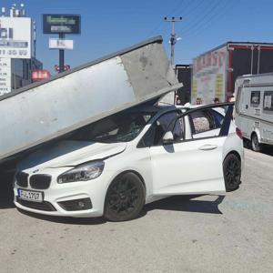 Üzerine reklam totemi devrilen otomobilin sürücüsü yara almadan kurtuldu