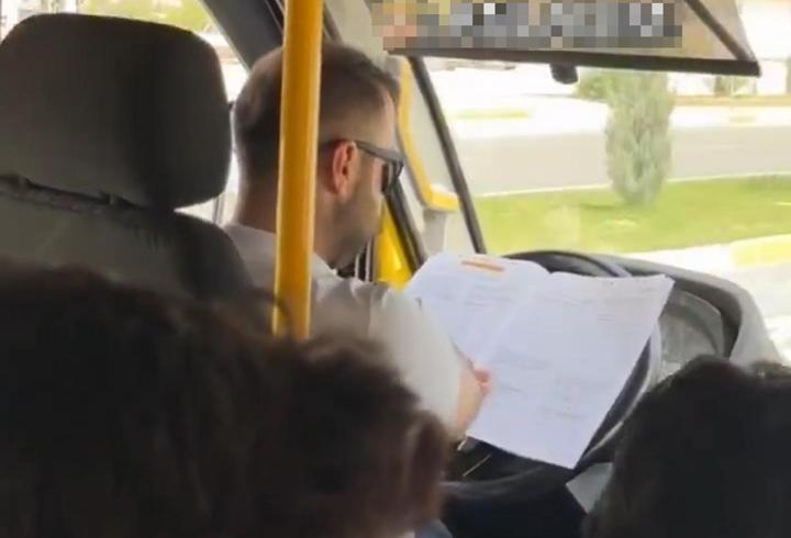 Minibüs şoförü, direksiyonda kitap okurken görüntülendi