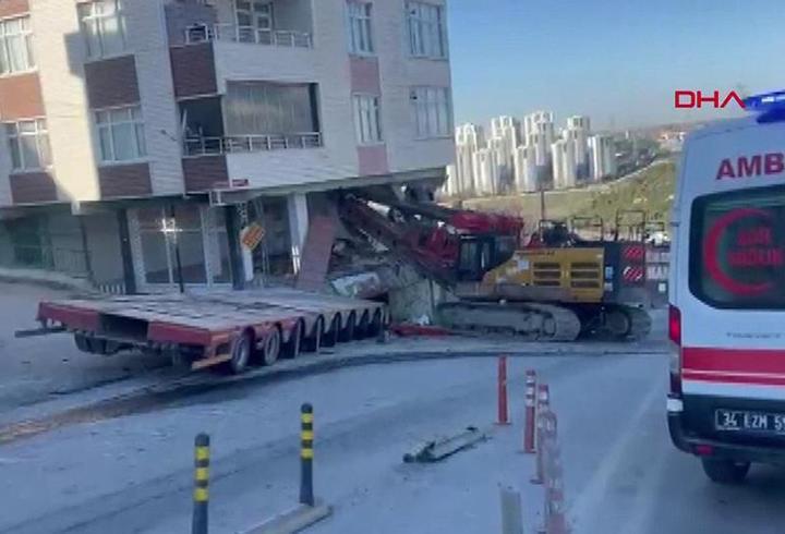 TIR’dan düşen iş makinesi binaya daldı
