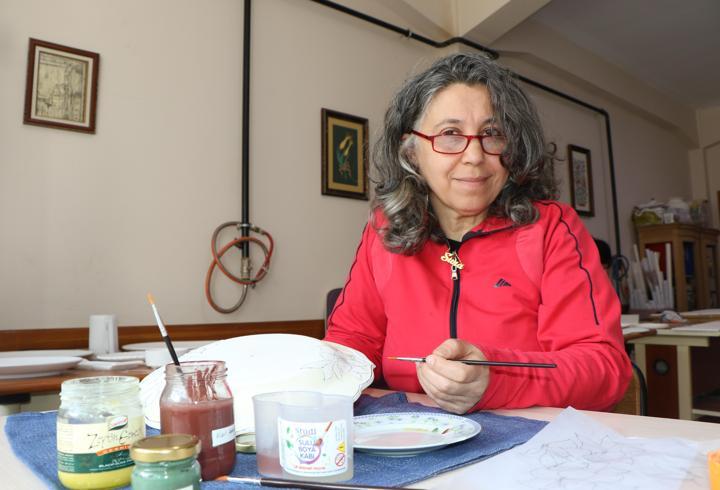 Kazanın izlerini çini fırçasıyla siliyor