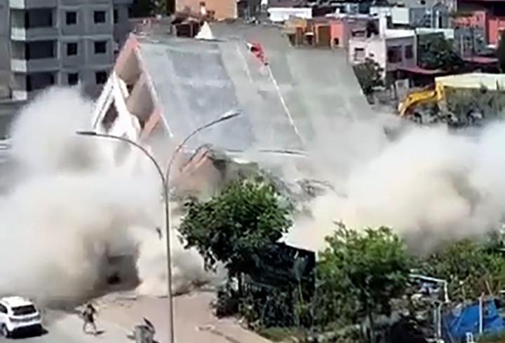 Apartmanın yıkımı sırasında, kaldırımdaki kadın enkaz altında kalmaktan son anda kurtuldu