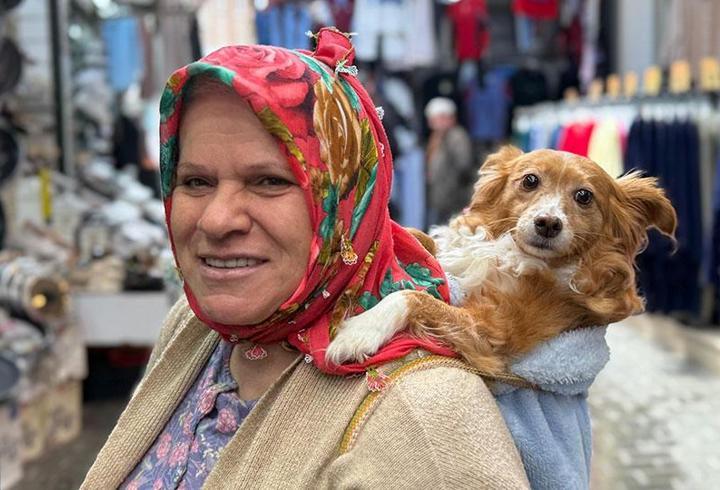 İnsanlardan korkan köpeğini sırtında gezdiriyor