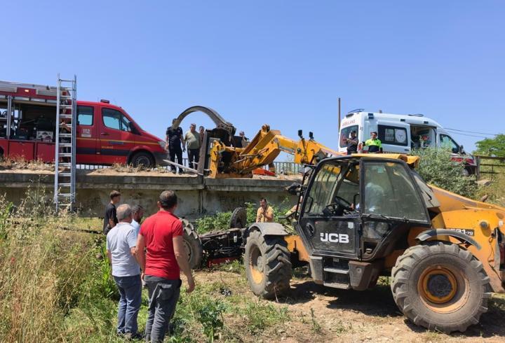 Köprüden düşen traktörün altında kalan sürücü iş makinesiyle kurtarıldı