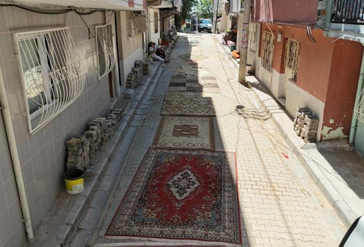 Onarılmayan yola mahalleliden çözüm: Her yere halı serdiler!