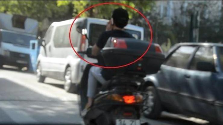 Cep telefonu kullanan motosikletli trafikte tehlike saçtı