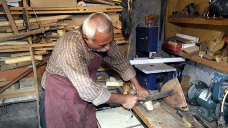 Evinin bodrumunda kurduğu atölyede saz yapıyor