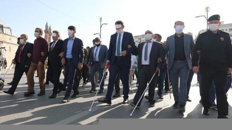 Protokol üyeleri engelliler için göz bandı çekerek yürüdü