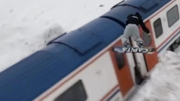 Snowboardla trenin üzerinden atladı