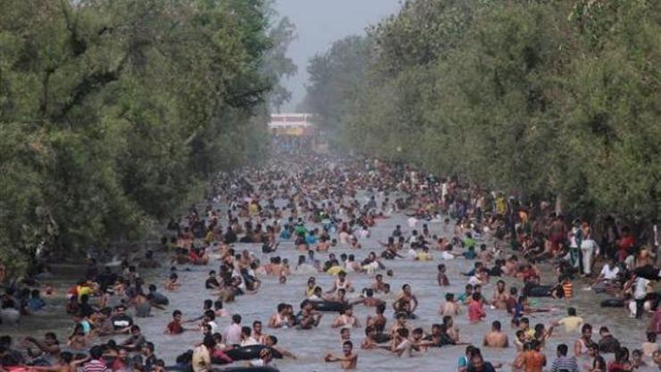 Pakistanlılar su kanalında serinliyor