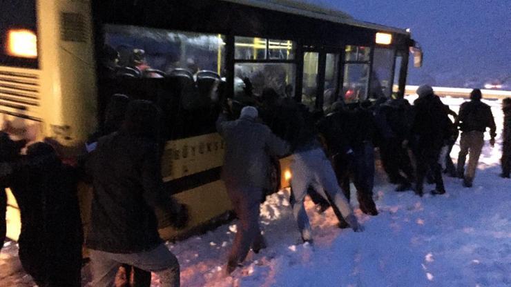 Dağ yolunda karda kayan otobüsü yolcular itti