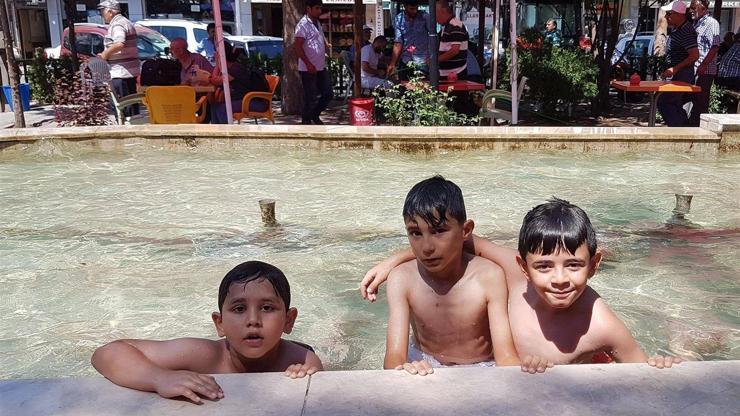 Sıcaktan bunalan çocuklar süs havuzuna akın etti