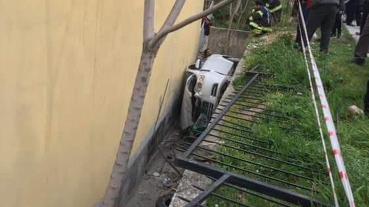 Otomobil ev ile bahçe duvarı arasına yan yatarak devrildi