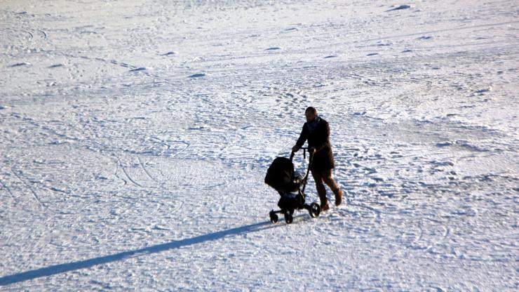 Buz tutan gölün üzerinde bebek pusetiyle yürüdü