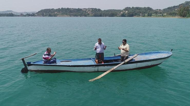 Su altında kalan mezarlığa sandalla giderek dua ettiler