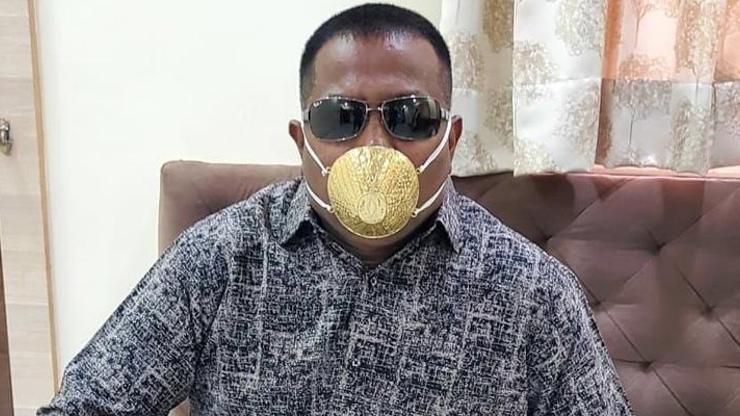 Koronavirüse karşı altın maske takıyor
