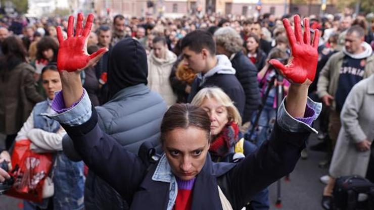 Belgradda yüzlerce kişi sokağa indi Ellerini kırmızıya boyadılar